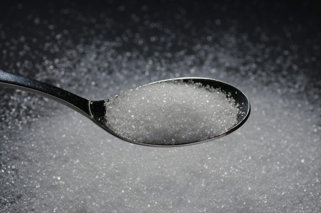 a spoon filled with sugar on top of a table